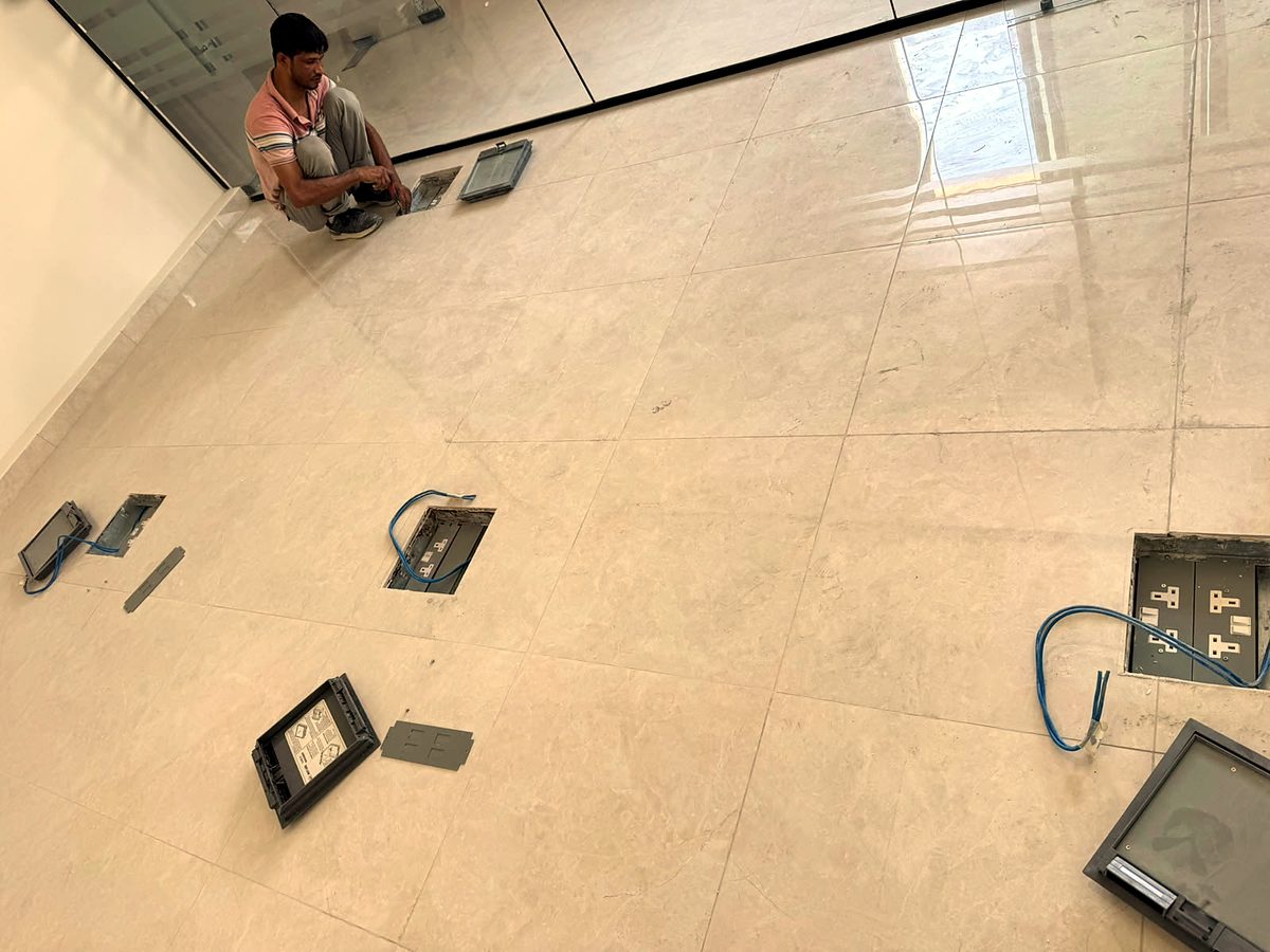 Mizan's team fitting floor boxes for power and data in a new Dubai office